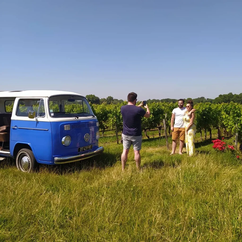 combi-couple-photo-oenotourisme Combi VW vintage bleu et couple posant devant les vignes du Médoc lors d’un circuit d’oenotourisme